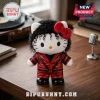 Hello Kitty plush wearing a red Thriller-style leather jacket and curly black wig, standing on a wooden desk.!