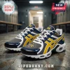 Michigan Wolverines NCAA basketball championship sneakers in navy, gold, and grey mesh on a locker room floor.!