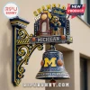 Michigan Wolverines wall-mounted decorative bell with NCAA championship trophy, mascot figurine, and basketball motifs.!