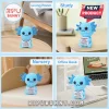 Blue crocheted axolotl plush holding a white sign with motivational text on a wooden table, study desk, and nursery bed.!