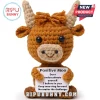 Amigurumi brown highland cow crochet toy holding a sign that reads Positive Moo and motivational text on white background.!