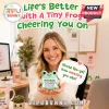 Woman holding a small light green crocheted frog plush with a sign that reads Never Fro-get the difference you make.!