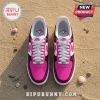 Nike Air sneakers with fuchsia pink and black colorway featuring Toronto Blue Jays logos on insoles, sitting on sand.!