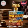 Stack of colored glass books forming a decanter with a golden open-book stopper on a wooden desk with antique books.!