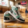 Custom Nike Air Jordan high-top sneakers in white, black, and mint green leather on a wooden basketball court floor.!