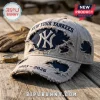 New York Yankees 1903-2026 embroidered distressed cap in beige with navy blue accents resting on a wooden surface.