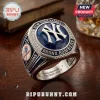New York Yankees 27x Champions Ring with blue center, NY logo, and Bronx Bombers text on a wooden surface.
