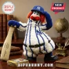 New York Yankees Mascot Plush Pillow wearing a striped uniform, blue cap, and holding a baseball bat on a wooden desk.