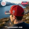 Red and blue baseball cap featuring a white compass star logo, the year 2026, and geometric trim against a fjord background.!