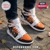 High-top sneakers featuring Gritty mascot graphics, orange and black leather panels, and white laces on stone ground.!