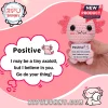 Pink crochet axolotl plushie held in hand, featuring black bead eyes and a card reading Positive I believe in you.!