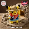 Pikachu plush toy wearing a tan safari hat and blue vest with red scarf, standing on a rocky cave diorama base.!