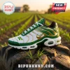 Custom green, white, and gold Nike Air Max Plus sneaker featuring tractor branding, resting on a heavy farm tire.!