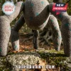 Grey felt creature with teal polka dots standing on a mossy rock in an outdoor forest setting.!