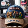Blue and beige baseball cap featuring a Roblox logo, 3D character patches, and Level Up text on a wooden desk.!