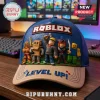 Blue and beige baseball cap featuring embossed Roblox logo and five 3D game characters on a wooden desk with a keyboard.!