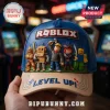 Blue Roblox baseball cap featuring five 3D game character figurines and beige brim with embroidered text in arcade setting.!