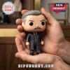 Vinyl figure of a man with gray hair and mustache wearing a dark three-piece suit held in two hands.!