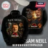 Black hoodie featuring a Sam Neill tribute print with Jurassic Park logo, dinosaur silhouette, and memorial dates.!