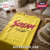 Bright yellow t-shirt with hot pink brush-style Scream text and Answer If You Dare caption on wooden table.!