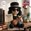 Crocheted Slash doll wearing a top hat and sunglasses holding a miniature electric guitar and an emotional support sign.!