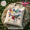 Off-white canvas tote bag featuring Snoopy holding a heart and flowers, autism awareness ribbon, and puzzle piece text.!