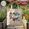 Canvas tote bag featuring Snoopy holding a red heart and flowers with colorful autism awareness puzzle piece lettering.!