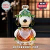Snoopy crystal figurine wearing a green hat with a scout badge, engraved 1950-2025 75th Anniversary on amber glass base.!