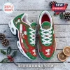 Snoopy Christmas themed sneakers featuring red and green patterns, white laces, and air-cushion soles on a snowy wood floor.!