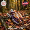 Orange and purple Halloween sneakers featuring cartoon Snoopy designs, pumpkins, ghosts, and white laces on autumn leaves.!