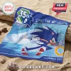 Sonic the Hedgehog 35th anniversary beach towel with blue runner graphics and golden ring on a sandy beach background.!