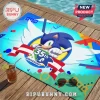 Sonic the Hedgehog 35th anniversary beach towel with blue, white, and yellow graphic design on wooden deck surface.!