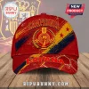 Spain National Team 2026 World Cup Champions red baseball cap with yellow accents and trophy graphic on wooden surface.