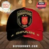 Spain National Team 2026 World Cup Champions red and black baseball cap with golden crest and lettering on wooden table.