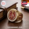 Spain National Team 2026 World Cup Gold Ring featuring a red crest, crown, and diamonds on a wooden surface.