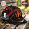 Spain National Team 2026 World Cup Trophy Cap in black with red and yellow geometric patterns on a wooden bench.