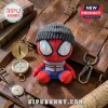 Spider-Man Brand New Day Beanie Plush Toy wearing a gray knit cap with iridescent lenses, seated on a leather bag.