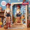 Taylor Swift doll in cowgirl attire with red hat, blonde braids, and cow print skirt, standing beside its display box.!