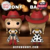 Vinyl figure of cowgirl character with red hat, blonde braids, white shirt, and cow-print skirt on wooden table surface.!
