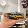 The Beatles Magical Mystery Tour 1967 AEC Reliance die-cast bus model with yellow and blue paint held in a hand.