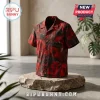 Short-sleeve button-down shirt with a red and black floral print on a stone display pedestal in a studio setting.!