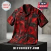 Short-sleeve button-down shirt with a red and black floral print on a dark stone pedestal.!