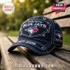 Dark denim Toronto Blue Jays baseball cap with brass studs, white embroidery, and 1977-2026 text on a wooden bench.!