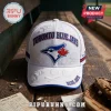 Toronto Blue Jays EST 1977 White Cap with blue embroidered team logo, baseball motifs, and red maple leaf on wooden table.