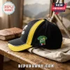 Black and yellow baseball cap featuring an embroidered green Tour de France jersey patch on a wooden surface.!