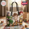 Toy Story character leather tote bag featuring Woody, Buzz Lightyear, Jessie, Rex, and Slinky Dog on a cream background.!