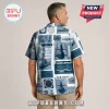 Man wearing a blue and white short-sleeve button-up shirt featuring US Navy submarine graphics and text patterns.!