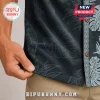 Dark navy tropical button-down shirt with light blue monstera leaf pattern, wood-style buttons, and tan trousers.!