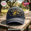 West Coast Eagles denim baseball cap with gold embroidered eagle logo, metallic rivets, and text on a wooden bench.!