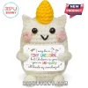 Crocheted white amigurumi unicorn plush with yellow horn, pink cheeks, and holding a sign about being uniquely wonderful.!